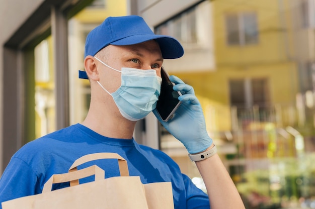 Close-up delivery man talking on phone