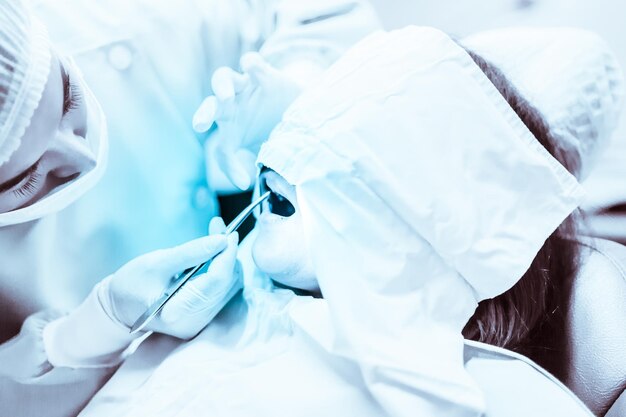 Foto close-up di un dentista che esamina i denti di una ragazza