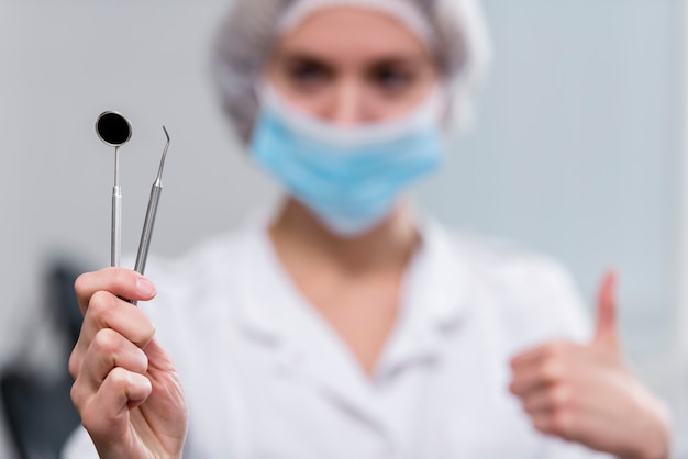 Photo close-up dentist holding medical tools