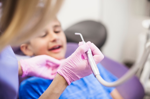 Photo close-up of a dentist holding ultrasonic scaler