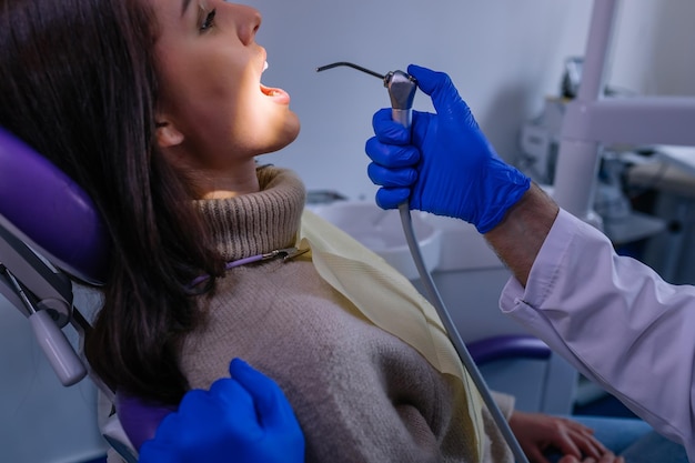Крупный план стоматологов и пациентки с открытым ртом стоматолога