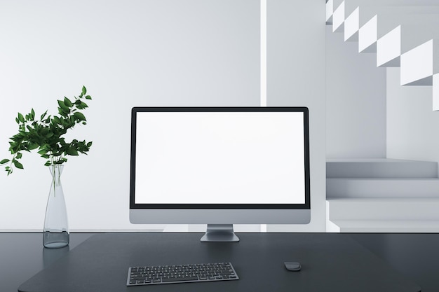 Close up of designer desktop with empty white computer screen frame decorative items and modern interior in the background Mock up 3D Rendering