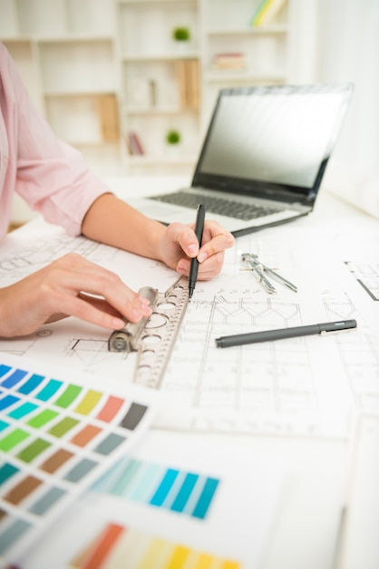 Close-up of designer's hands working with architectural plan