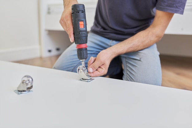 Close up detail of furniture and hands of carpenter worker with professional tool