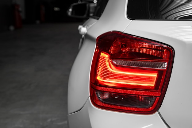  Close up detail on one of the LED red taillight modern white sedan car. Exterior detail automobile.