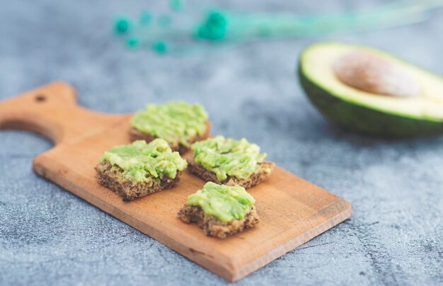 Close up detail view of avocado bread bites over rustic backdrop