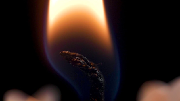 Close up detail of white wax lit candle flame and wick on isolated black background andle lights