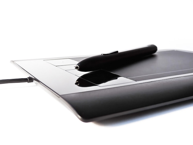 Photo close-up of digitized pen on graphics tablet against white background