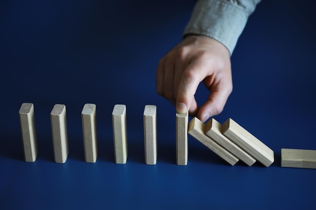 Close-up dik domino-houtblok op een rij, stop het vallen, wees stabiel in het concept van de crisisbedrijfsoplossing