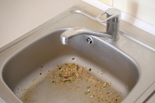 Close up on dirty clogging kitchen sink drain with food particles