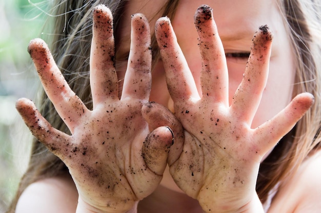 Foto close-up delle mani sporche di una ragazza