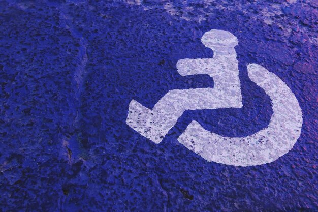 Foto close-up del cartello per disabili sulla parete blu