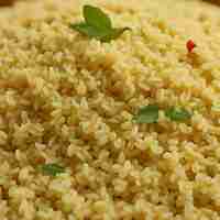 Photo a close up of a dish of brown rice with green leaves