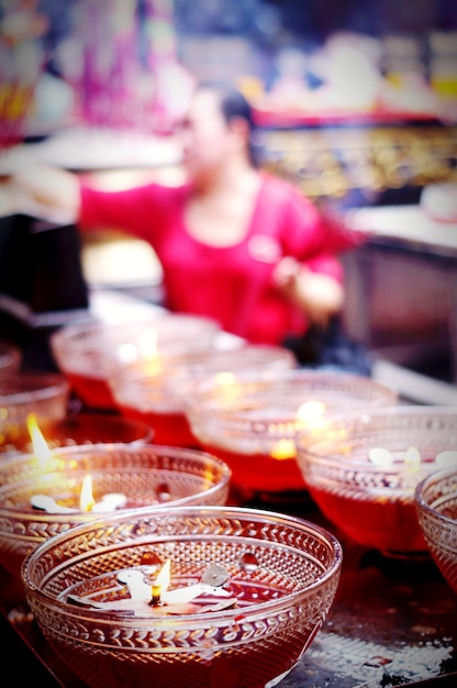 Foto close-up di diyas con una donna sullo sfondo al mercato