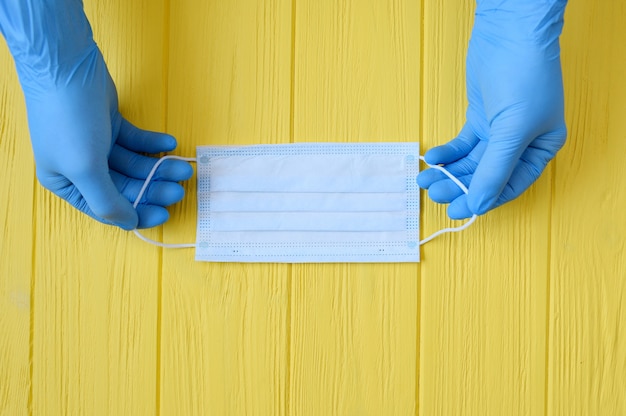 Close up of doctor hand gloves with a medical face mask for protection against infection.