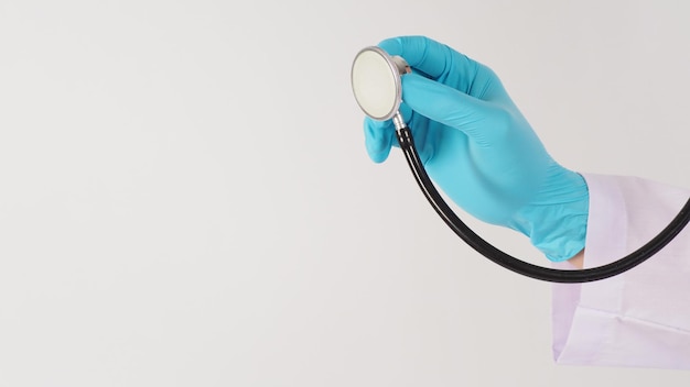 Close up of doctor hand holding stethoscope.Hand wear the blue medical glove and a long-sleeve gown on white background.