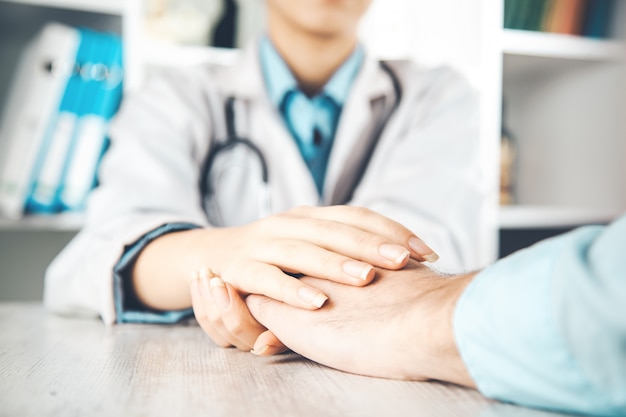 Close up of doctor hands reassuring her female patient