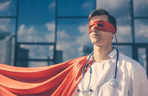 Close up. doctor hero in a Superman Cape standing on a city street.