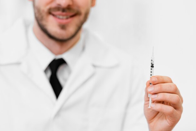 Photo close-up doctor holding syringe