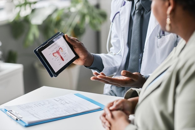 Photo close up doctor holding tablet with female reproductive health charts