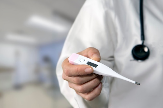 Photo close-up of doctor holding thermometer