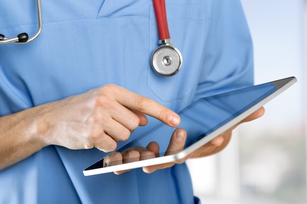 close-up doctor at hospital working with tablet pc