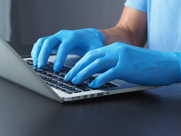 Close-up. doctor in medical gloves for using laptop. concept protection from coronavirus.