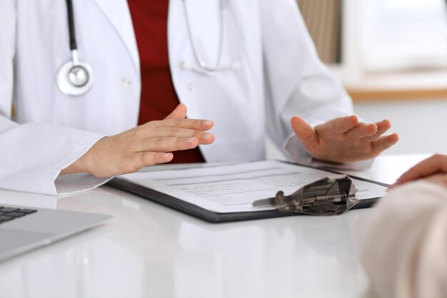 Close up of a doctor and patient hands while discussing medical records after health examination