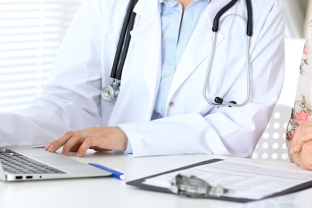 Close up of a doctor and  patient sitting at the table, just hands.