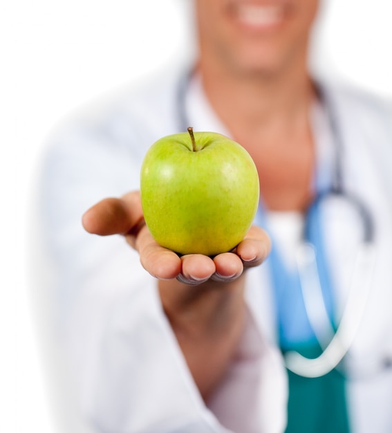 Foto primo piano di un medico che presenta una mela verde