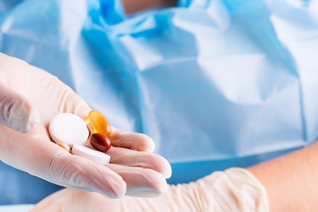 Close-up of a doctor's hand holding assorted medicines pills