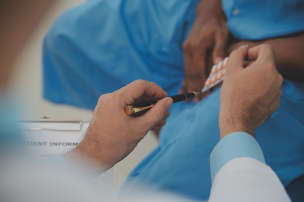 Close up of doctor sitting on bedside of male patient in hospital