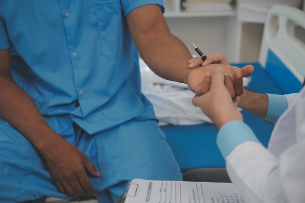 Foto primo piano del medico seduto sul capezzale del paziente maschio in ospedale