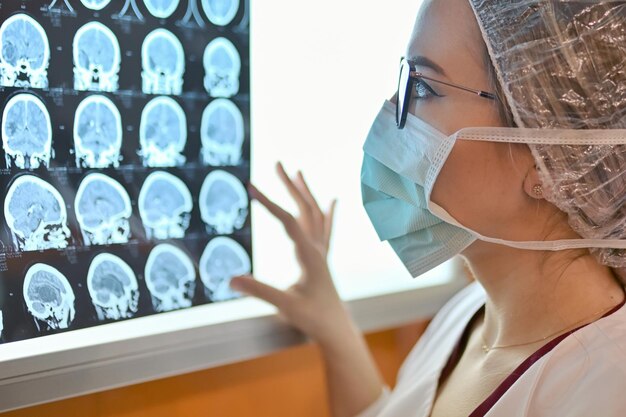 Close-up of doctor wearing mask examining x-ray