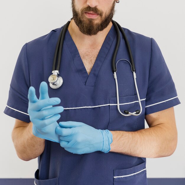 Close-up doctor with stethoscope and gloves