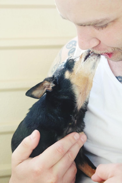 犬が家で男の唇を舐めるクローザップ