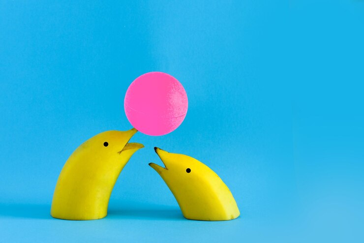 फोटो close-up of dolphins made of bananas and ball over blue background