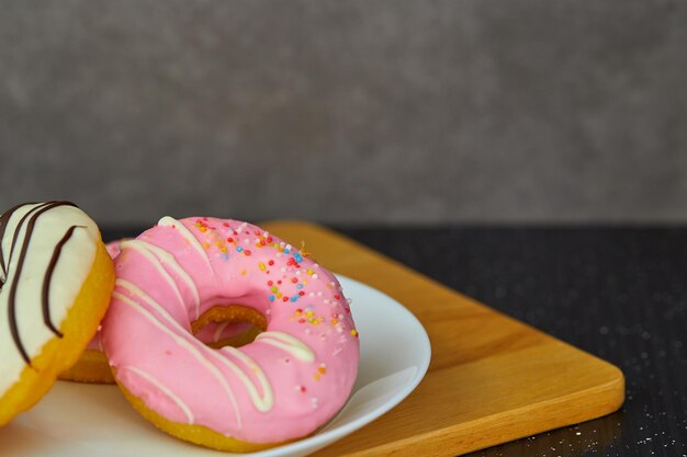 Close-up of donuts in plate on cutting board over table