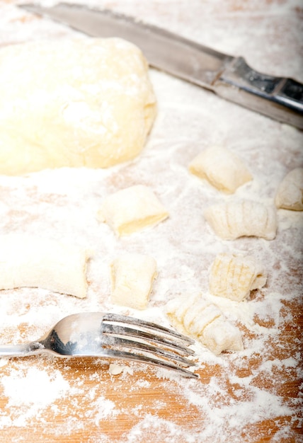 Foto close-up di pasta e farina con la forchetta sul tavolo