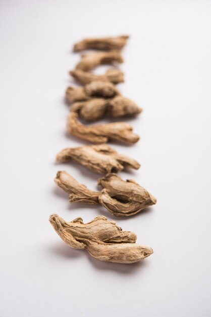 Photo close up of dried ginger or sonth isolated on white surface