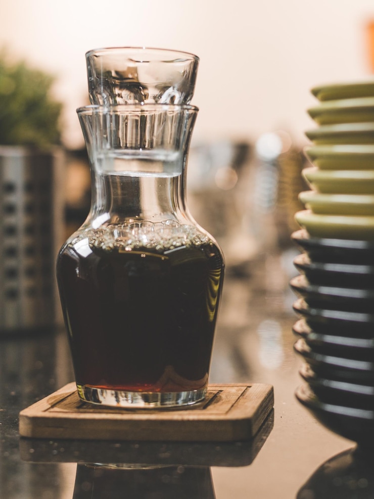 Photo close-up of drink in glass bottle on wooden table