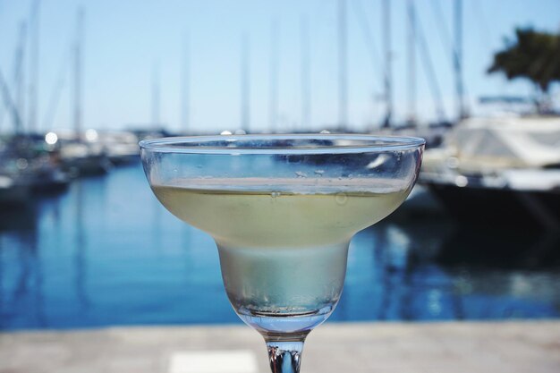 Foto close-up di un drink al porto contro il cielo