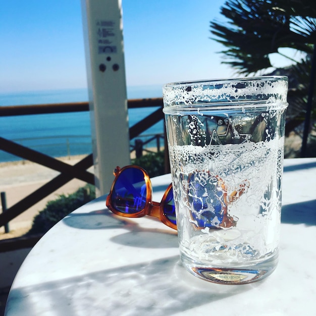 Foto close-up di una bevanda sul tavolo contro il mare