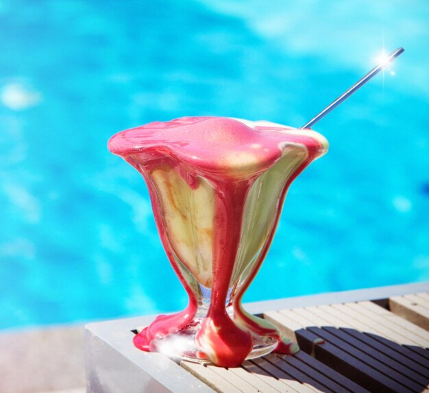 Close-up of drink on table against swimming pool