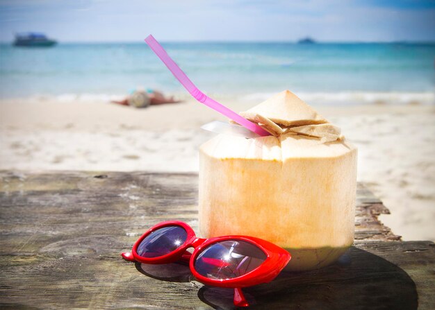 Photo close-up of drink on table at beach