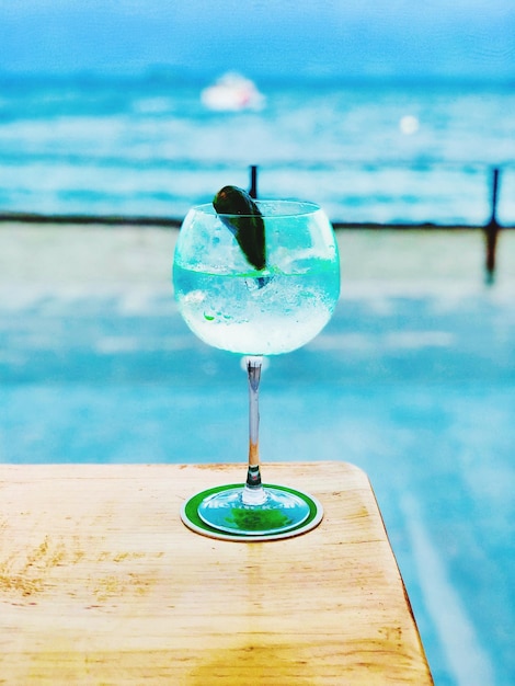 プールに照らして木製のテーブルに置かれた飲み物のクローズアップ