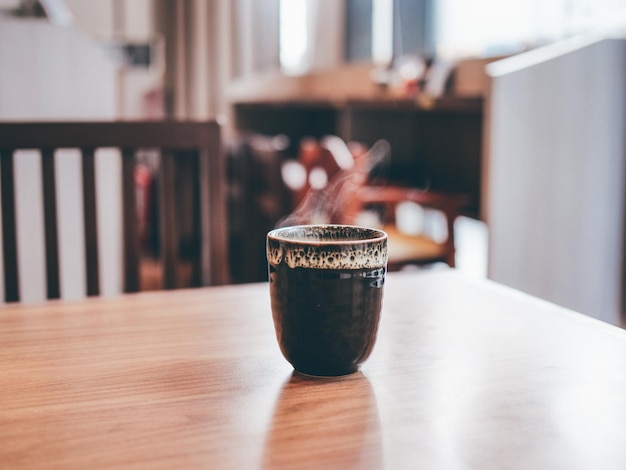 Photo close-up of drink on wooden table at cafe