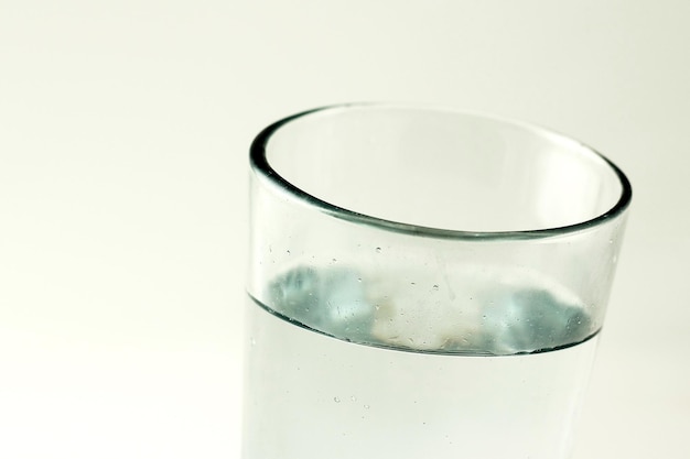 Photo close-up of drinking water in glass against white background