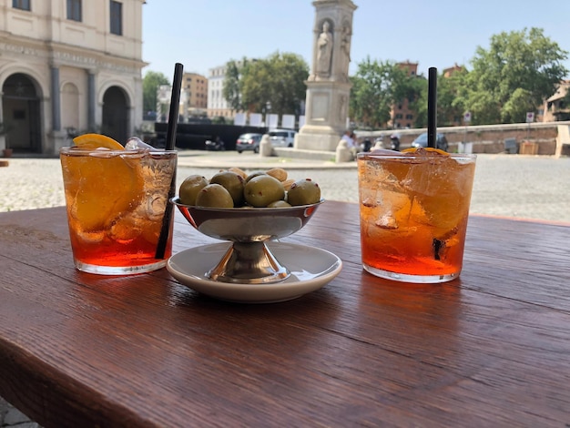 Close-up of drinks and olives on table in city