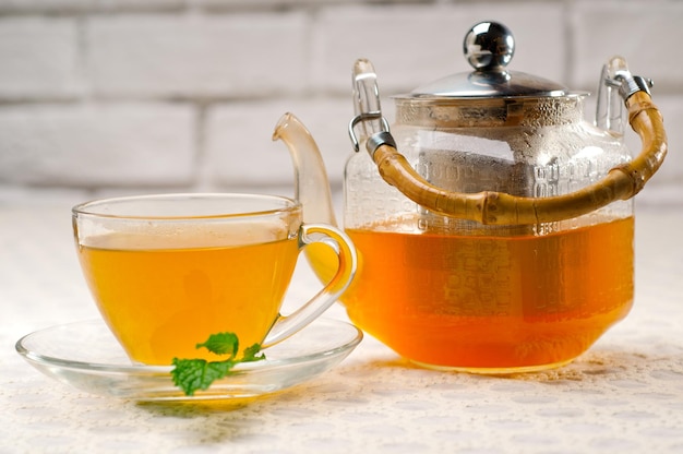 Close-up of drinks with cup and teapot on table